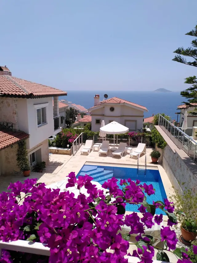 BookNoFees: brīvdienu māja, Kalkan, Kas, Antalya, Antālija, Turcija – Terase ar peldbaseinu, saulessēdekļiem, saulessargu un skatu uz jūru