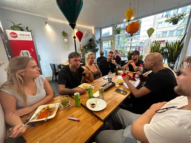 BookNoFees: Uzkodu bārs – Good morning Vietnam – Aachen – Restorāns ar garu galdu un krāsainām laternām, kas karājas no griestiem, foto 4