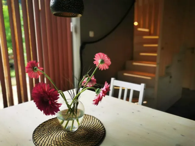BookNoFees: brīvdienu māja, Hieflau, Štīrija, Austrija – Ēdamistaba ar baltu galdu, vāzi ar rozā ziediem un koka kāpnēm