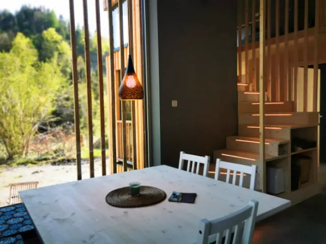 BookNoFees: brīvdienu māja, Hieflau, Štīrija, Austrija – Ēdamistaba ar baltu galdu, piekaramo lampu un koka kāpnēm ar apgaismojumu