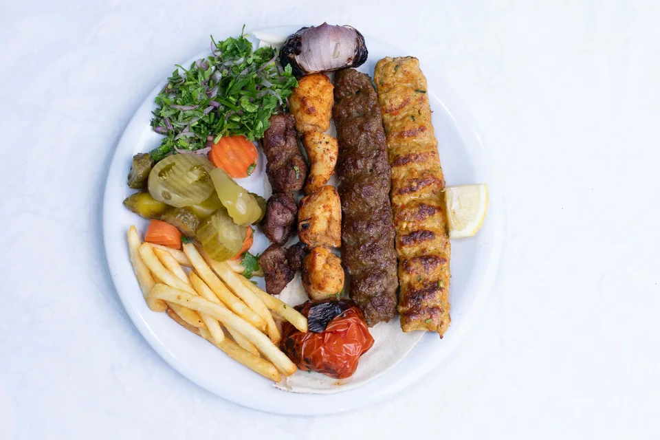 BookNoFees: Piemēra fotoattēls: Grilēti kebabi, pasniegti ar salātiem un frī kartupeļiem