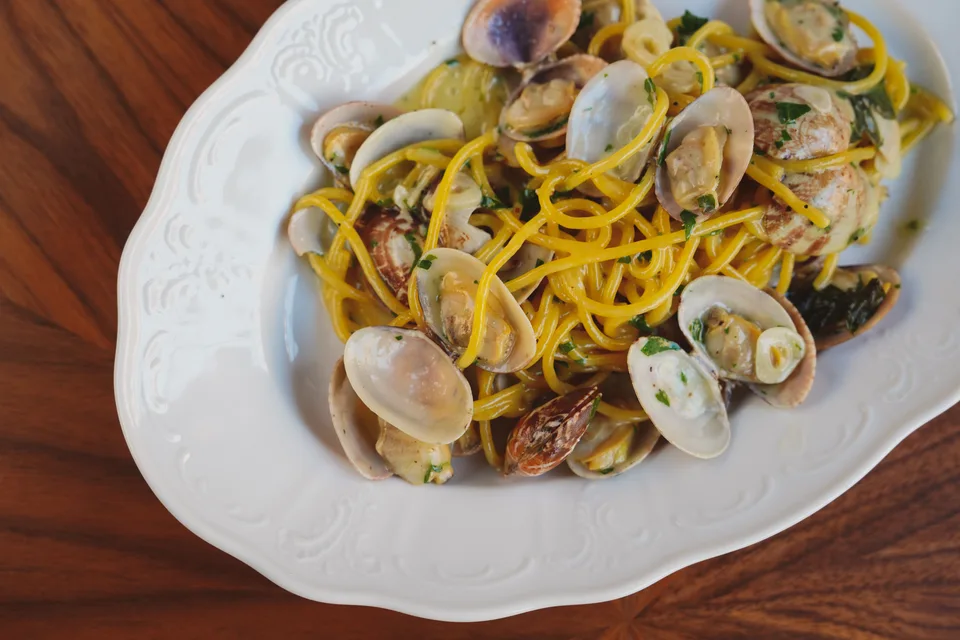 BookNoFees: Piemēra fotoattēls: Spageti ar gliemenēm uz baltas šķīvja